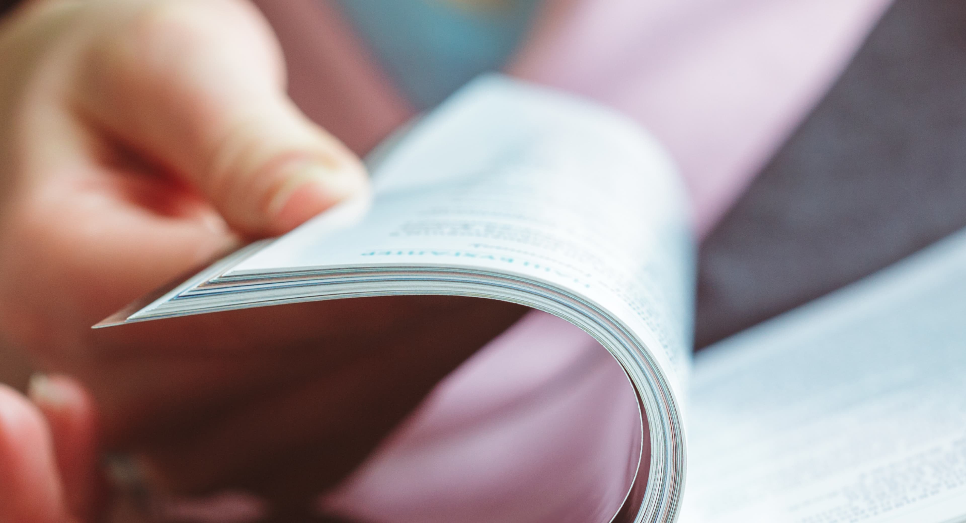 Annual Reports — hands turning magazine pages