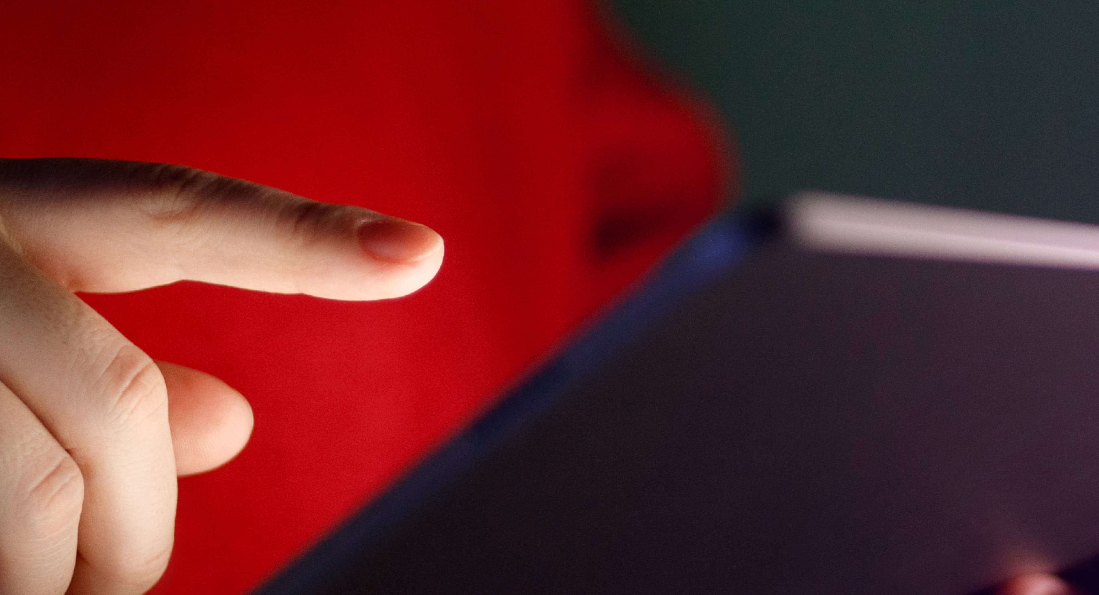 IFRS Reports — finger reaching for tablet on red
